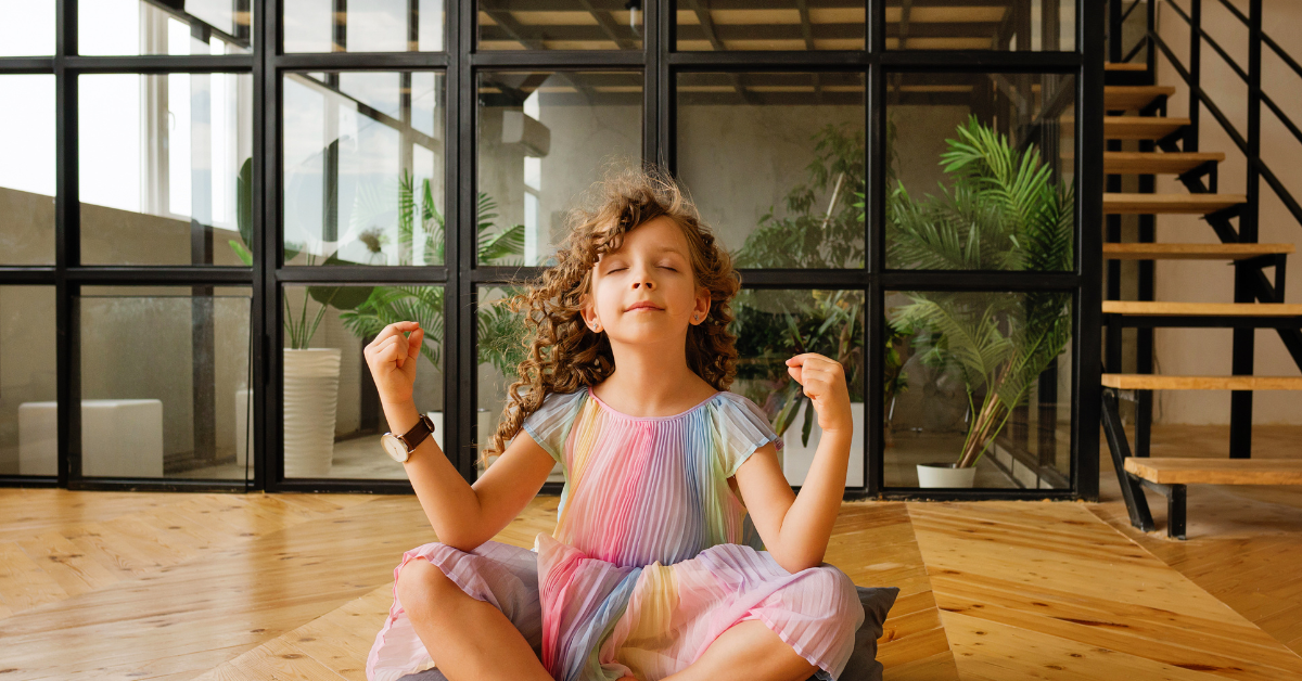 young girl in rainbow dress in lotus pose