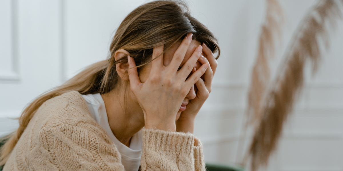Woman holding her head in her hands