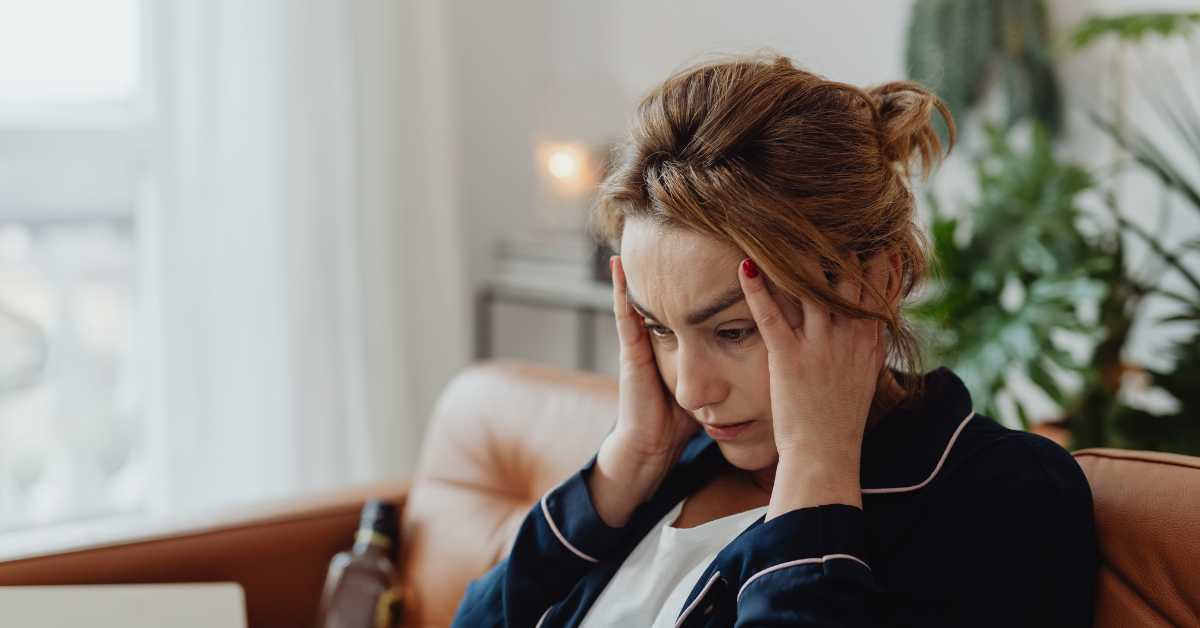 Woman in bathrobe pulling hair while looking at her device