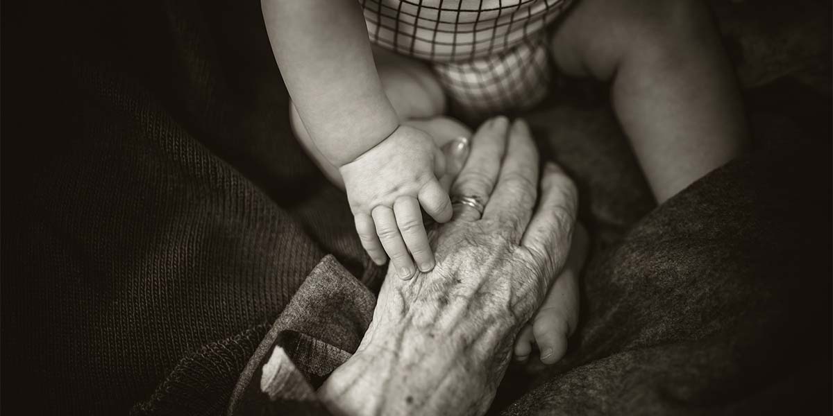 A child's hand holding an old man's hand