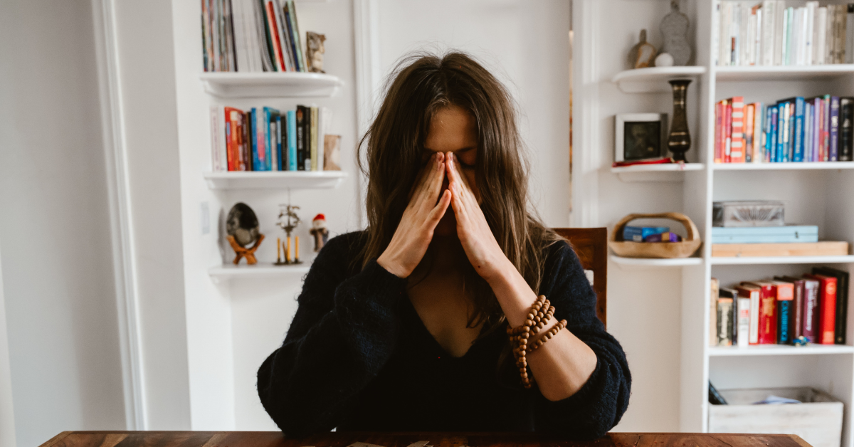young adult in black shirt crying at college after learning of parent's divorce