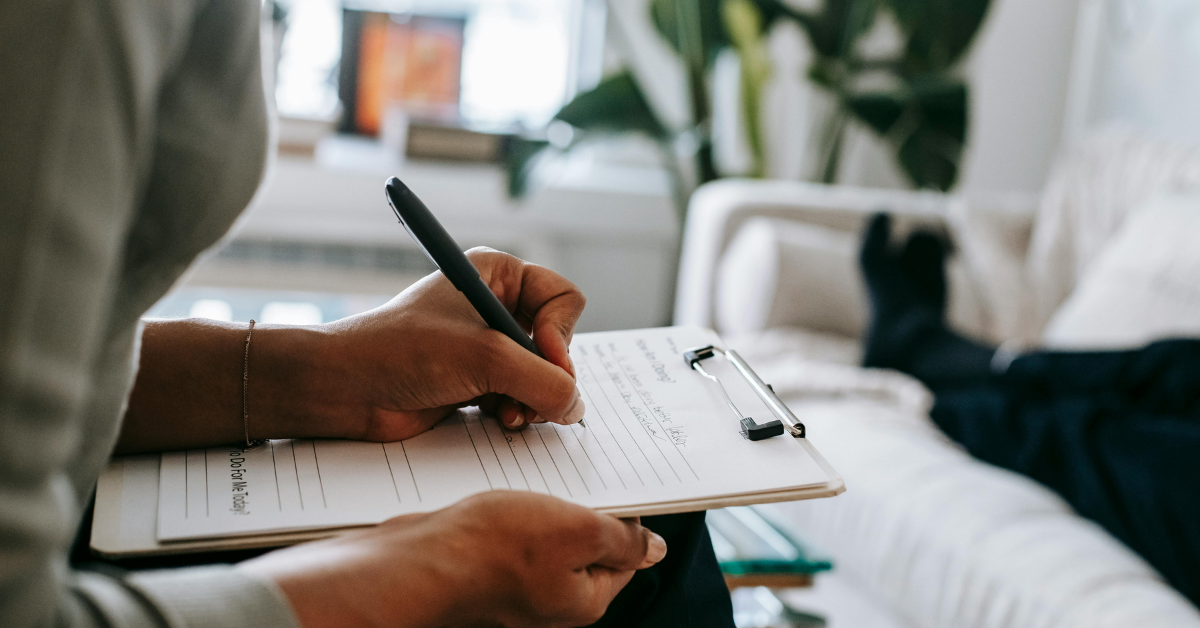 left hand with pen creating checklist in therapy office for suicide safety plan
